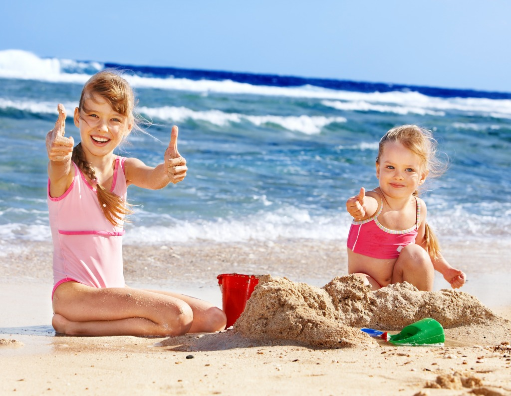 Дети на пляже играют с песком