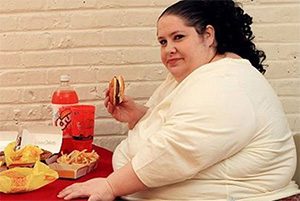 толстая женщина ест гамбургер