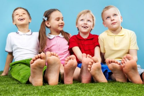 дети сидят на траве с босыми ногами